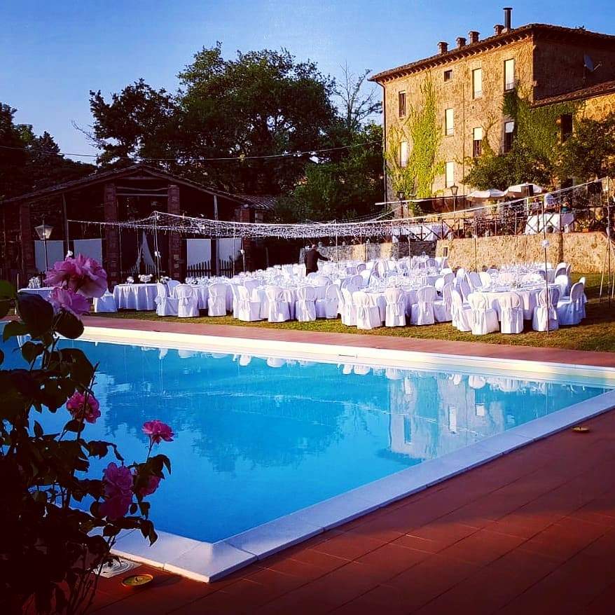 Wedding reception tables by the pool at Villa Le Querce